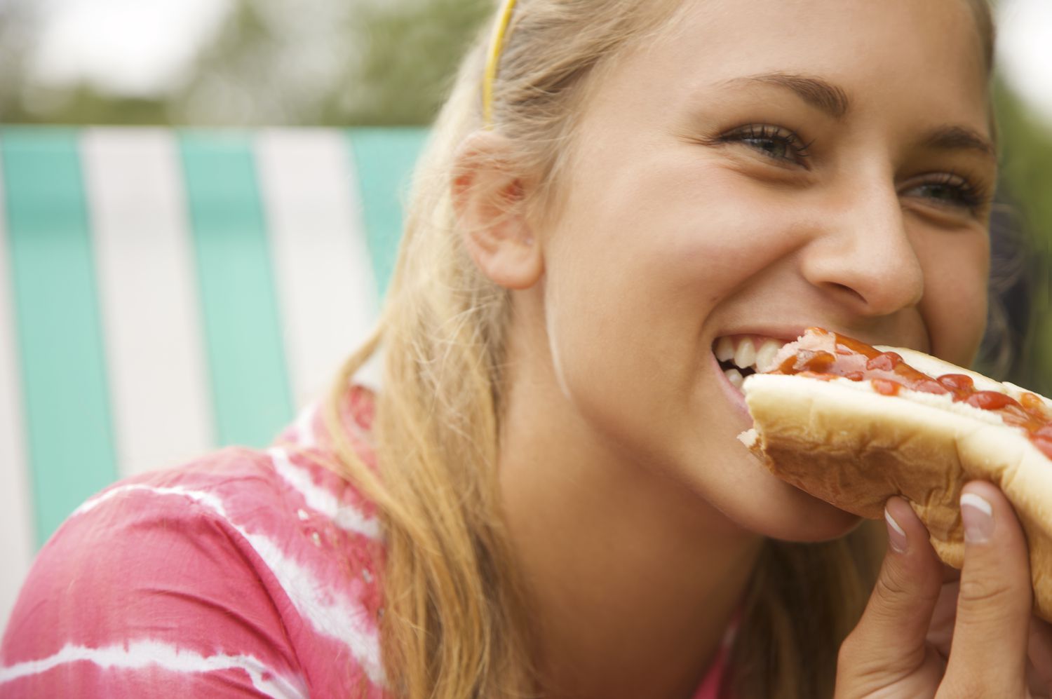 Close-up van een tienermeisje dat een hotdog eet