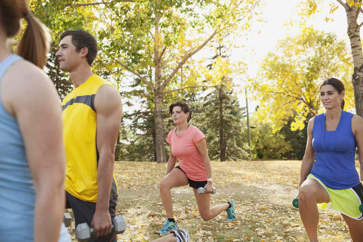 Mensen die gewichten gebruiken tijdens outdoor fitnessles.