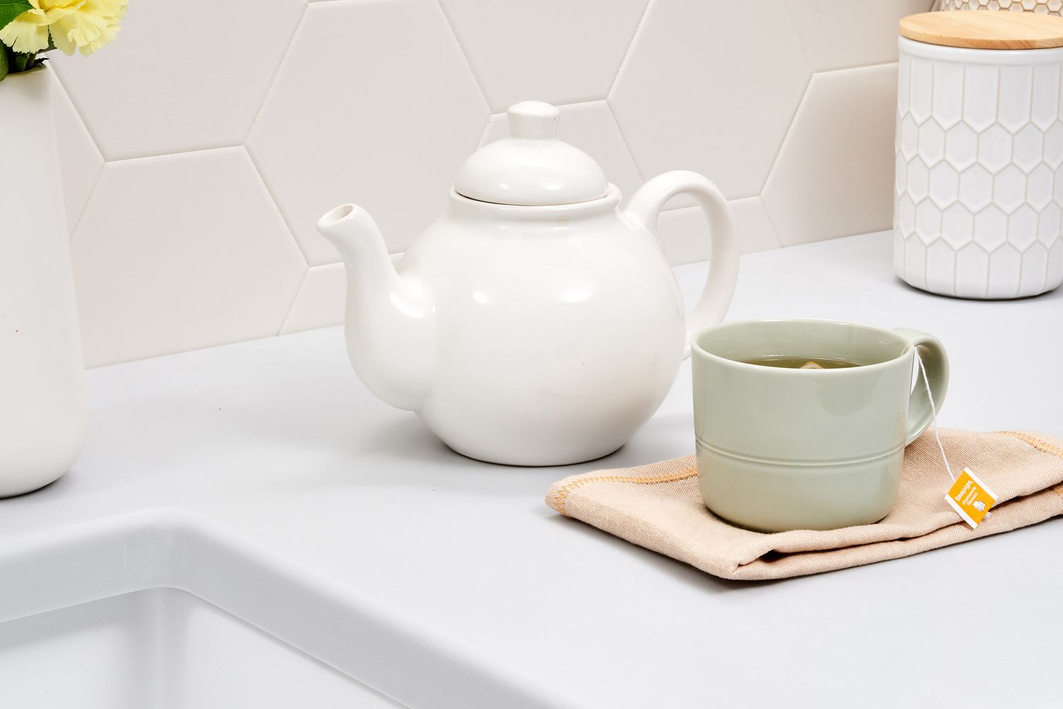theepot en kopje thee met kruiden in de keuken