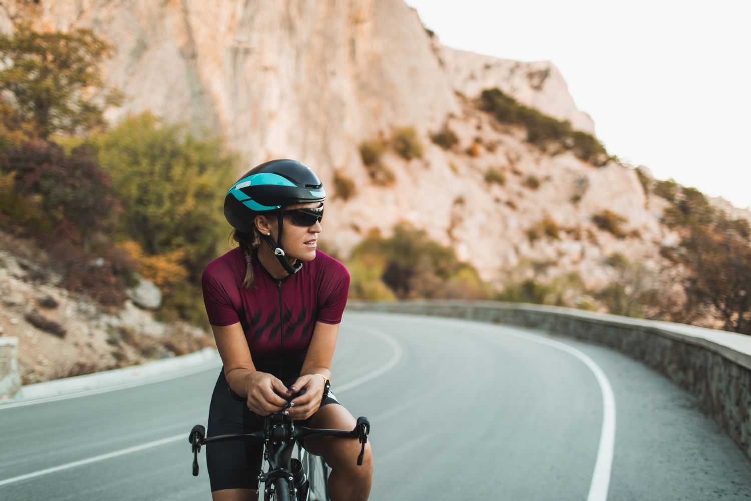 Portret van fietser vrouw op racefiets met zonnebril en helm