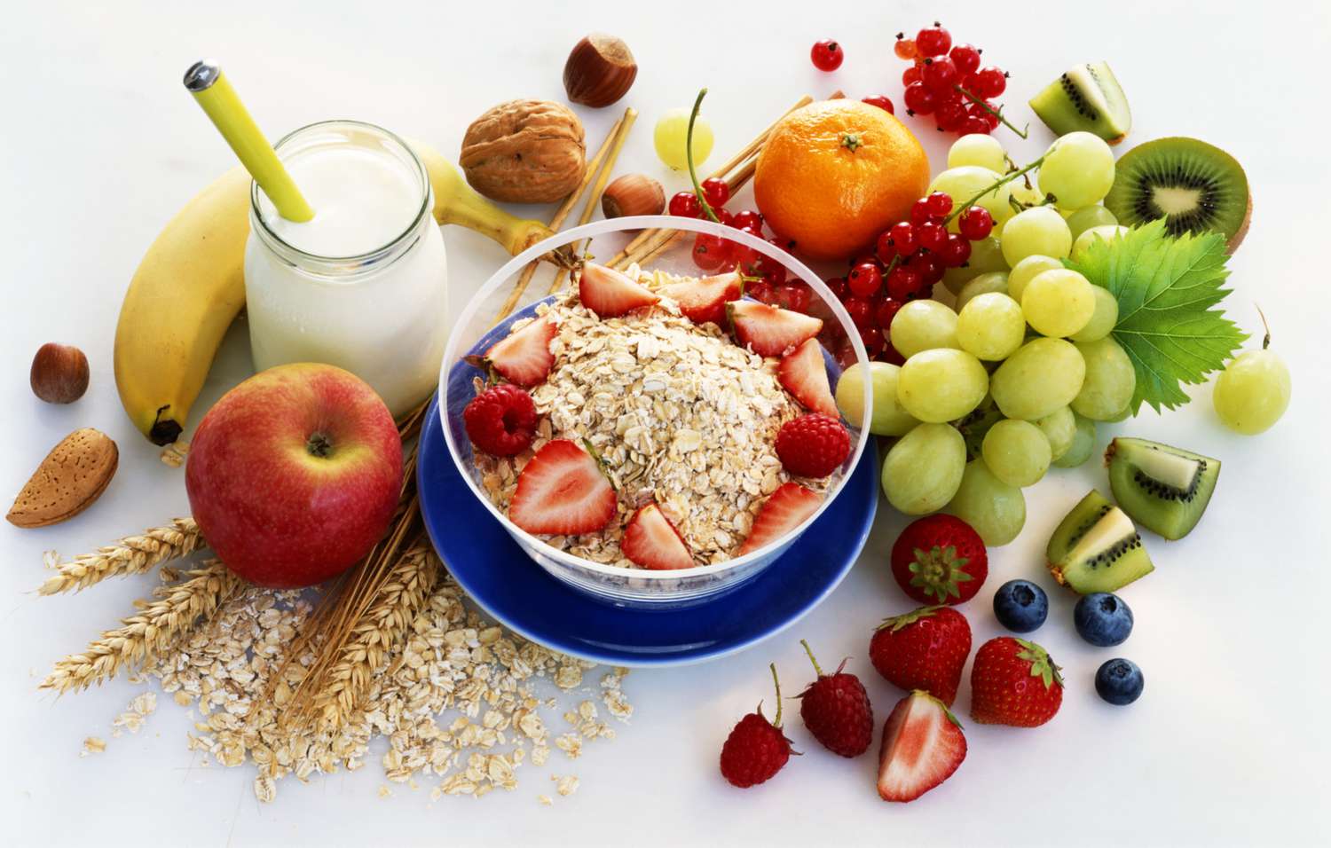 gezonde ontbijtproducten, waaronder fruit en havermout, op een wit tafelblad