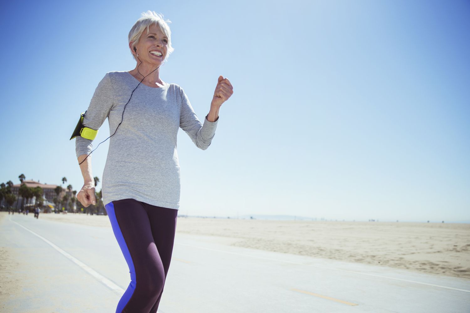 Senior vrouw die jogt op strand boardwalk
