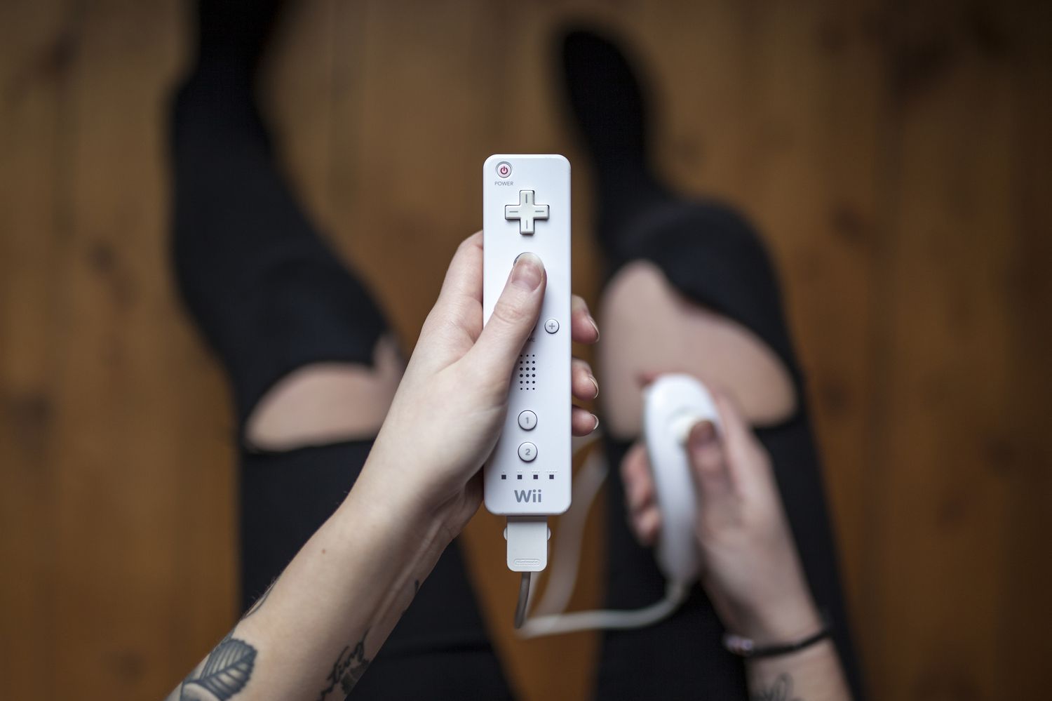 Vrouwenhanden die de Nintendo Wii-controller vasthouden